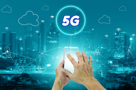 5G network interface and icon concept,hand holding mobile smart phone with cityscapeの写真素材
