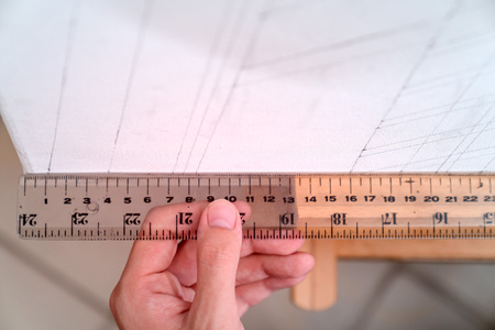 hand holding ruler with canvas backgroundの写真素材