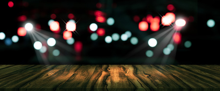 top desk with blur restaurant background,long wooden table and blurred bokeh of night street backgroundの写真素材