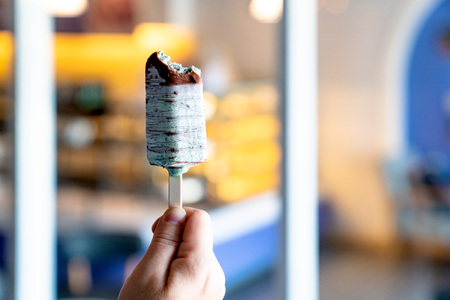 Hand holding green chocolate ice cream sticks with bokeh blur backgroundの写真素材