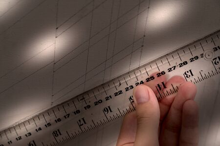 hand holding ruler with canvas background