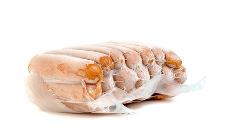 closeup frozen sausage in plastic bag with ice crystals isolated on white background の写真素材