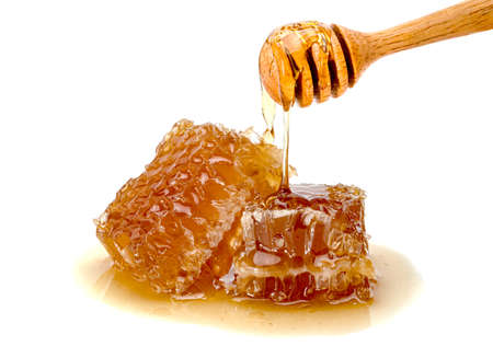 Fresh Honeycomb slice and wooden honey dipper isolated on white background