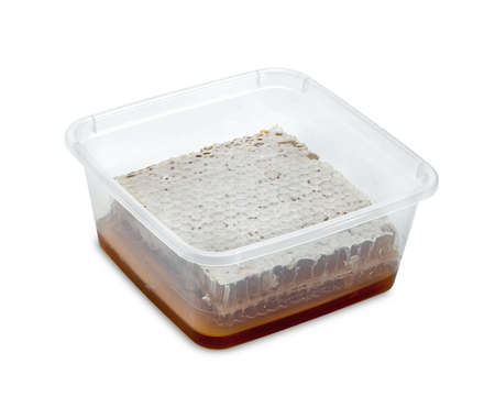 Fresh Honeycomb slice and honey in plastic box isolated on white backgroundの写真素材