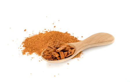 cinnamon sticks and powder with wooden spoon isolated on white backgroundの写真素材