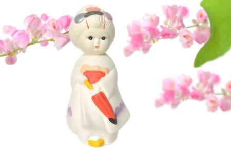 Japanese traditional doll and Mexican creeper flower on white backgroundの写真素材
