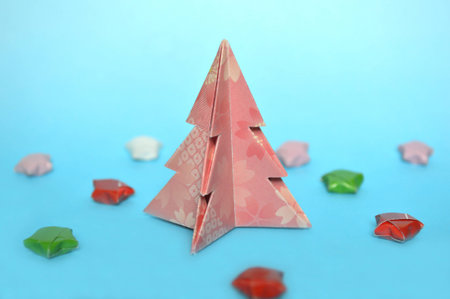 Origami Christmas tree on blue backgroundの写真素材