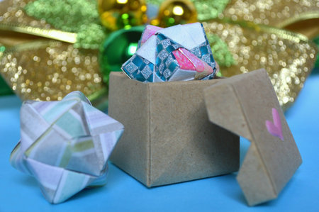 Modular origami sonobe ball and box on blue backgroundの素材