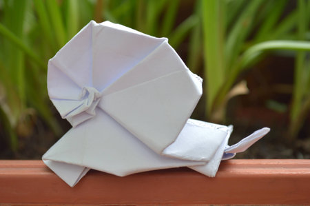 White origami snail on natural backgroundの写真素材