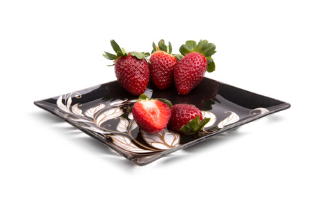strawberry on a black shiny plateの写真素材