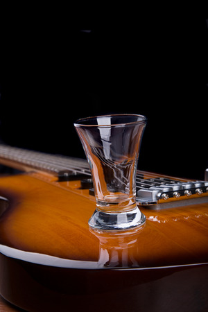 Glass of tequila on the electric guitarの写真素材