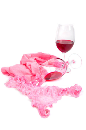 two glasses of red wine on a white background near pink pantiesの写真素材