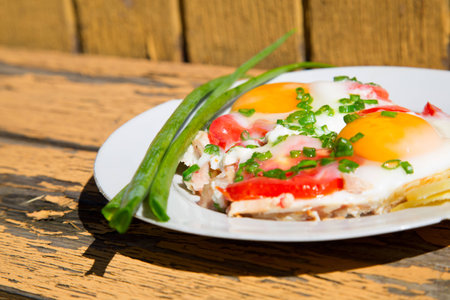eggs, green onions and tomatoes on an old wooden tableの写真素材