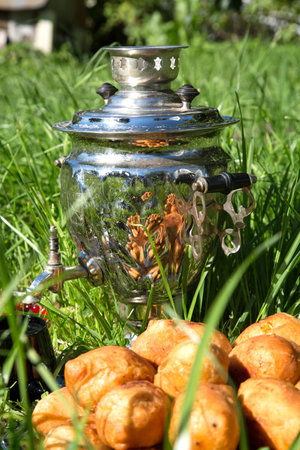 samovar on a green grass with cakes and candies berriesの写真素材