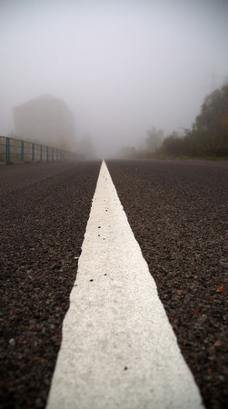 center stripe Asphalt road in an autumn fogの写真素材