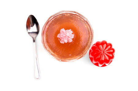 Cream balloon, jelly in glass bowl and spoon on white backgroundの写真素材