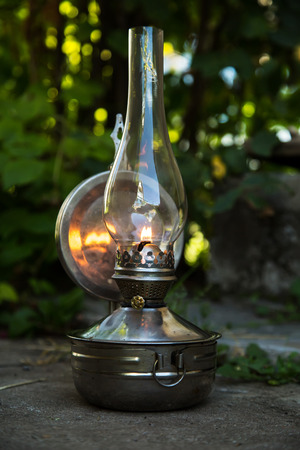 old kerosene lamp stands on the ground, outdoorsの写真素材