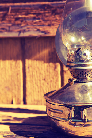 old kerosene lamp on the background of old wooden yellow wall, toningの写真素材