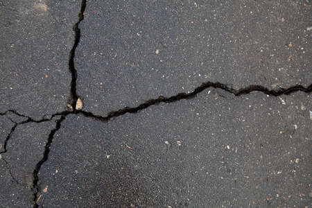 Cracks in the asphalt road. The surface of the asphalt.