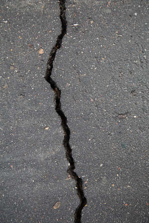 Cracks in the asphalt road. The surface of the asphalt.