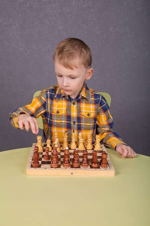 a little boy is playing chessの写真素材