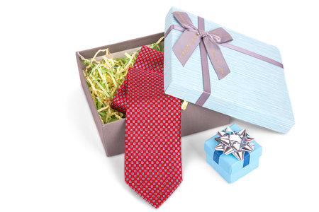 a slightly opened gift box with a bow, with a red tie insideの写真素材