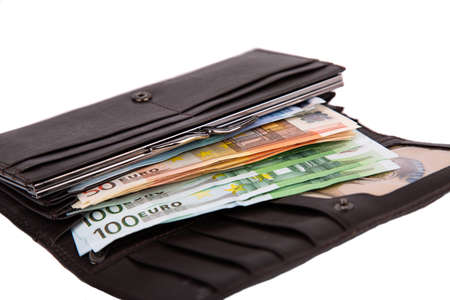 An open wallet full of money in denominations of 50 and 100 euros isolated on a white background...