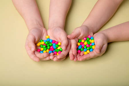 bright colorful sweets in children's palmsの写真素材