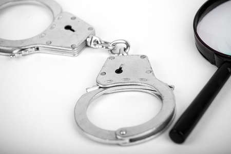 Handcuffed hands hold an open envelope with euro bills, on a dark wooden background