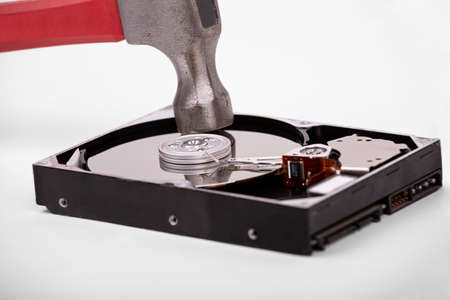 The hammer hits the plate of an open hard drive. Destruction of information from the hard drive