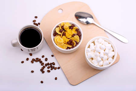 Light breakfast. Cereal with milk and coffee with marshmallow close-up