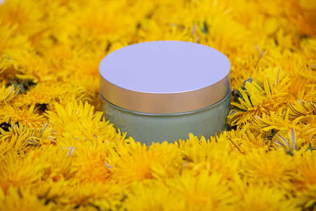 A jar lying in dandelion flowers, close-upの写真素材