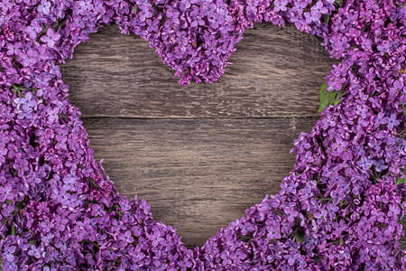 heart of purple lilac flowers on an old wooden background, copy spaceの写真素材