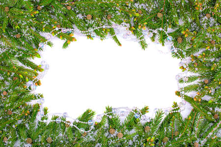 Christmas frame made of snow-covered fir branches with cones and glass beads. copy spaceの写真素材