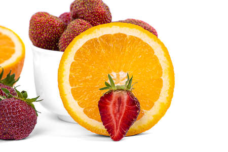 A berry of ripe strawberries, a piece of juicy orange, isolated on a white background, close-upの写真素材