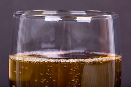 Bubbles in a glass of champagne, on a dark background, macro photographyの写真素材