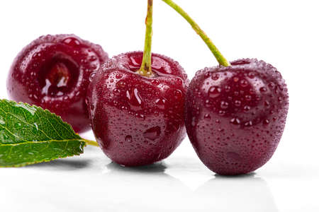 Ripe cherry in drops of water, isolated on a white background, macro photographyの写真素材