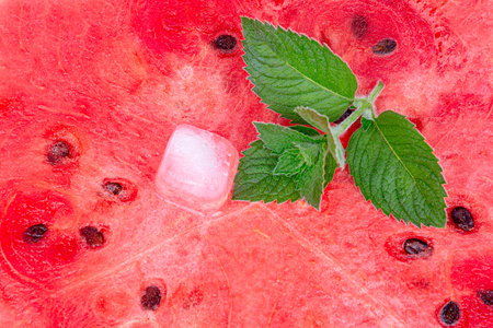 Watermelon background. watermelon pulp, a piece of ice and a sprig of mint, close-upの写真素材