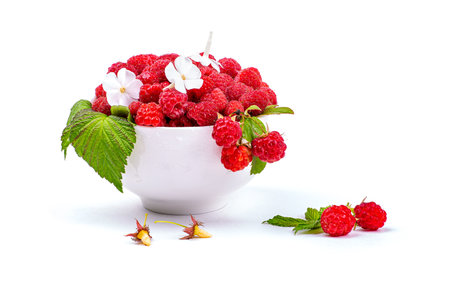 Ripe raspberries in a plate, close-up, isolated on a white background