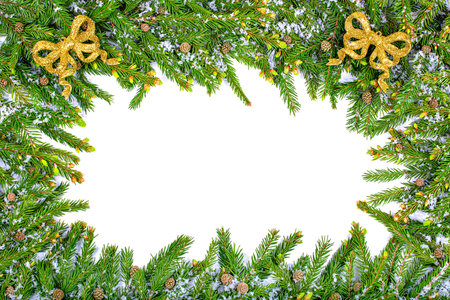 Christmas frame made of snow-covered fir branches with cones and golden bows. copy spaceの写真素材