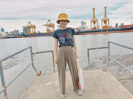 Asian woman standing on the local tilted pier on her vacation