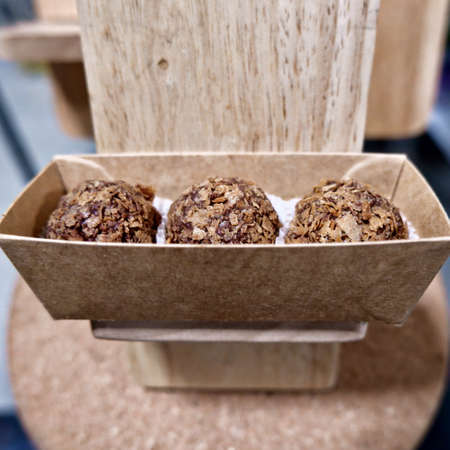 Straight view of chocolate balls with sprinkled flakes on the table