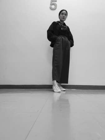 An Asian office worker standing on the 5th floor during her lunch breakの写真素材