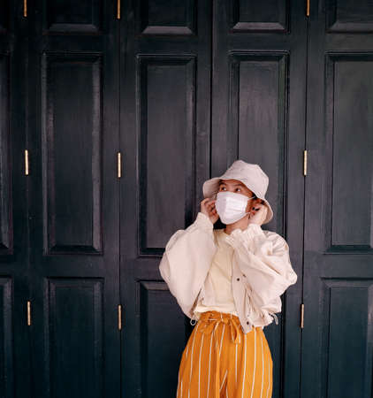 Portrait of an Asian woman wearing a surgical mask outdoorsの写真素材