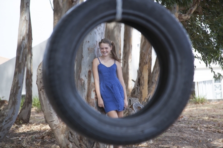 young girl playing with tyre swingの写真素材