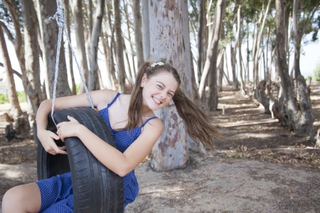 young girl playing with tyre swingの写真素材