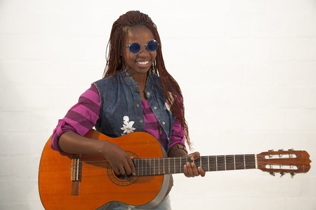 Beautiful african woman playing guitar against white backgroundの写真素材