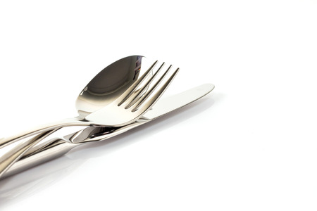 a spoon, fork and knife stacked up on a white background.