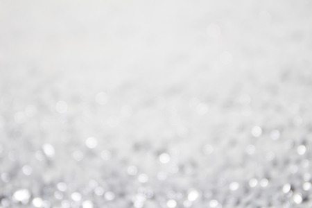 Silver festive glitter background with defocused lights