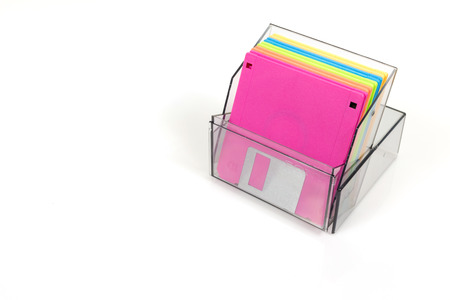 Colored diskettes in a transparent box with copy space.